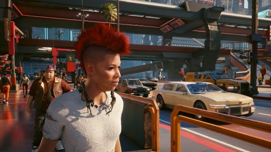 A person with a mohawk looks over a busy road in Cyberpunk 2077.