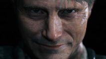 Death Stranding movie: Mads Mikkelsen grins threateningly as Cliff in Death Stranding, the image is a close-up of his face against a black background