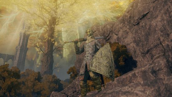 Elden Ring Steam sale: A Tarnished warrior holding a large sword over his shoulder and a brass shield on his left arm stands on some rocky cliffs with a golden Erdtree in the background