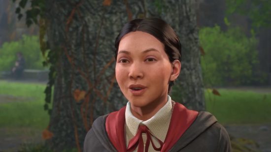 Hogwarts Legacy gameplay showcase tease hides Harry Potter secrets: a young girl in a black cloak with red accents stands in front of a tree