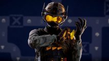Rainbow Six Siege update breaks friend invites: Solis wears grey digicam BDUs, black armour, and a face-concealing helmet with a bright yellow visor and twin antennae on the sides