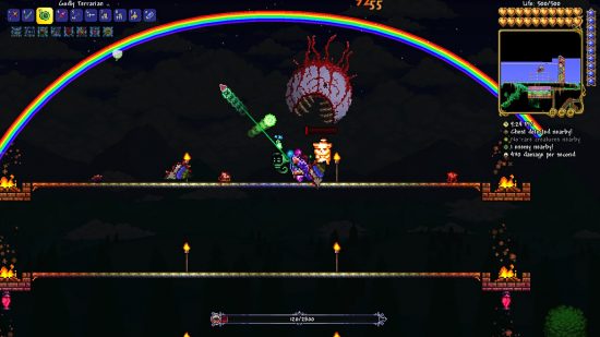 Terraria Steam success 2022 - a player fights the Eye of Cthulhu, a floating eyeball with large teeth, on a bridge - using a yoyo - as a rainbow arcs across the sky