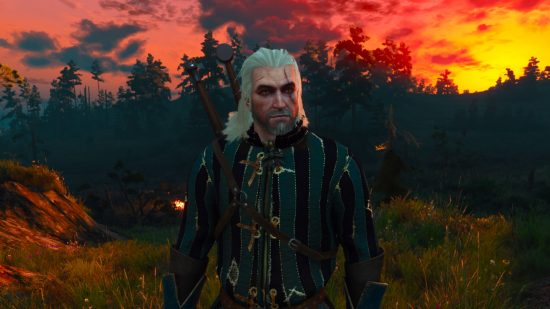 Witcher 3 hotfix: Geralt of Rivia wearing striped quilted armour, standing at the edge of a forest at sundown, the sky is fiery red, pink, and orange