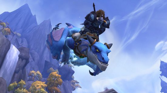 Un grande uomo che cavalca un drago blu di fronte a un cielo blu in World of Warcraft Dragonflight