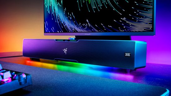 The Razer Leviathan V2 Pro soundbar sits underneath a gaming monitor with RGB light shining