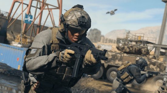 Call of Duty Season 2 start date: A US soldier in green battle dress and wraparound sunglasses readies an SMG as he advances with alongside an armoured vehicle through a construction site