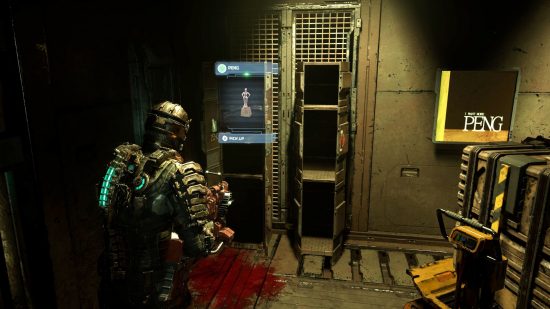 Dead Space peng: Isaac stands in the cargo bay facing a set of open lockers, one of which contains the elusive Peng treasure, as a stack of crates previously obstructing them sits to one side next to a Peng poster.