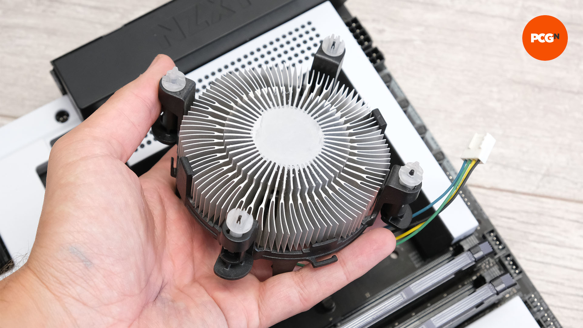 A CPU cooler in someone's hand ready for mounting on the motherboard