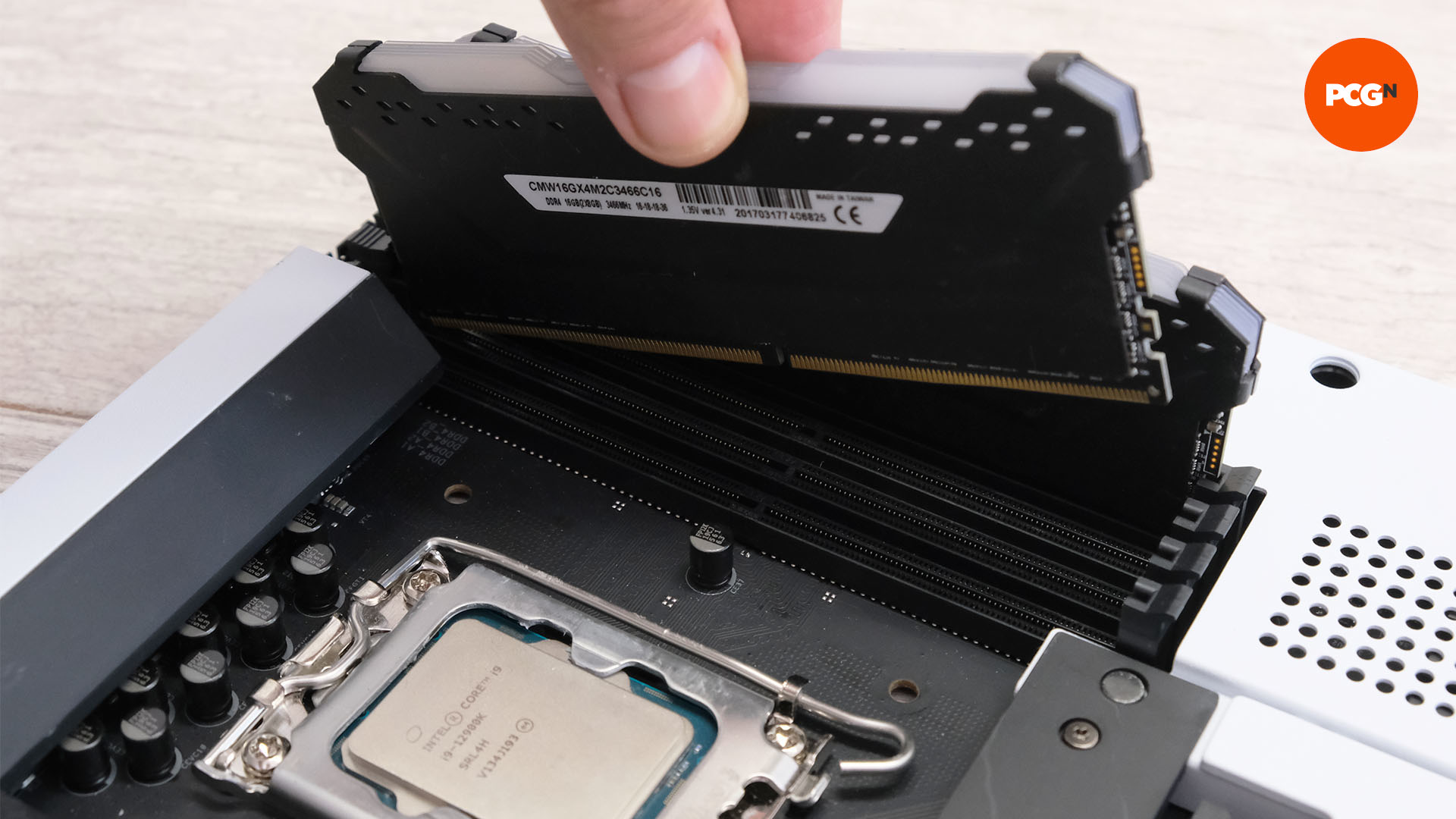 A hand places a stick of RAM into the slot on the motherboard