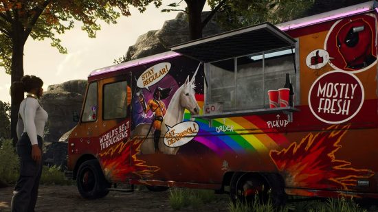 A food truck with bullet holes in it pained with a shirtless image of Marvel character Deadpool with flowing black hair on a unicorn, as well as a sign saying 'mostly fresh'