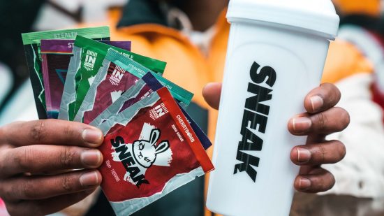 Sneak Energy sachets held next to a shaker.
