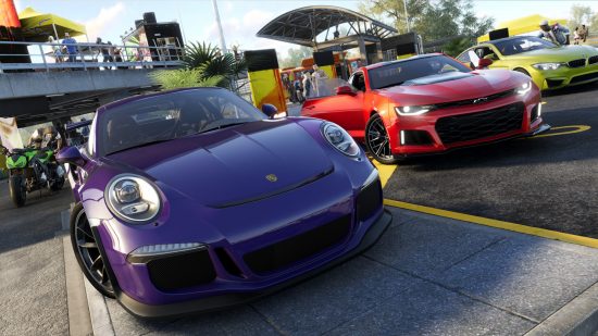 The Crew 3 announcement: Three sports cars - a purple Porsche, a red Camaro, and a yellow BMW coupe - are parked near a racing event in a sunny area with palm trees and motorcyclists milling nearby