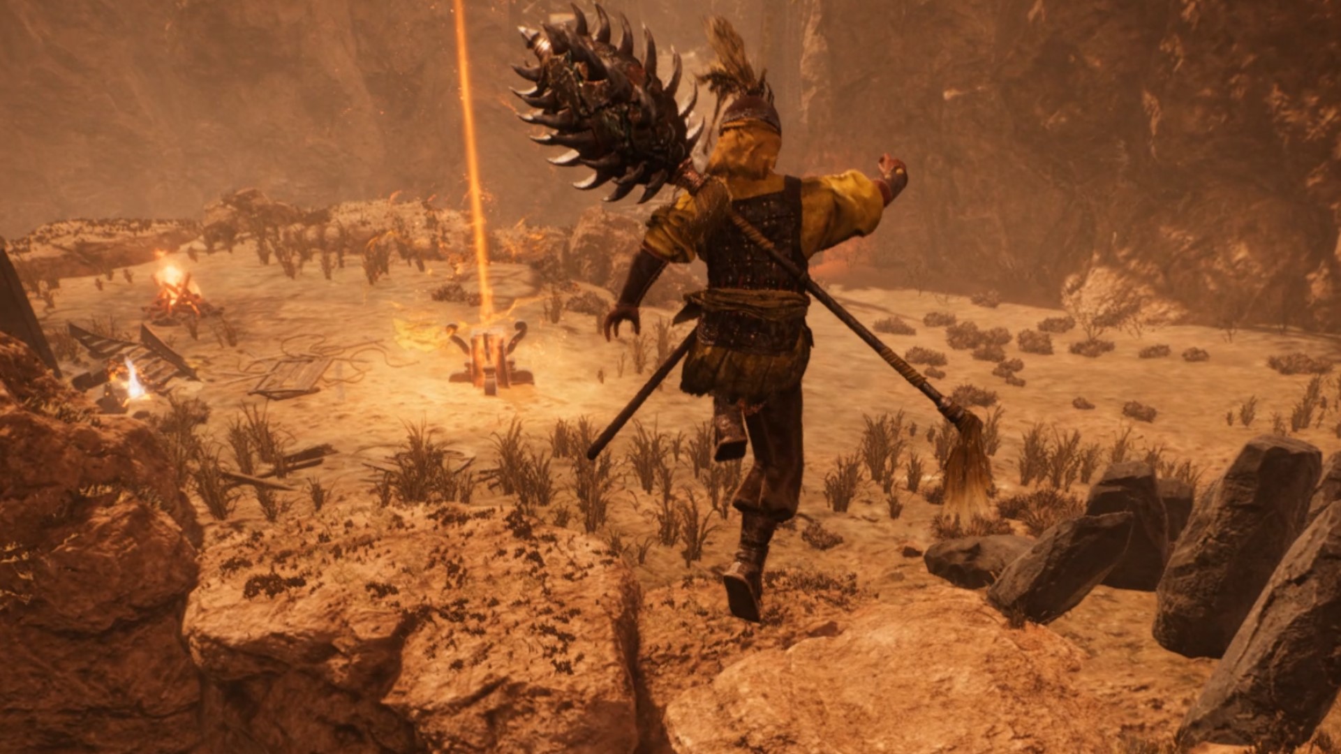 Wo Long Fallen Dynasty langsung: Seorang prajurit melompat melintasi jurang di kompleks ngarai gurun yang terjal, di dekatnya sebuah altar memancarkan sinar emas lurus ke atas