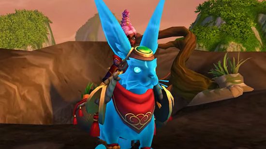 New WoW mount lets you bunny hop into Lunar New Year in style: A ghostly blue rabbit with a golden harness and a red and gold necktie stands in a forested area while a female gnome with pink hair rides on its bacl