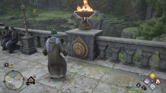 Hogwarts Legacy secrets - the wizard is trying to solve the bridge puzzle by turning the braizer.