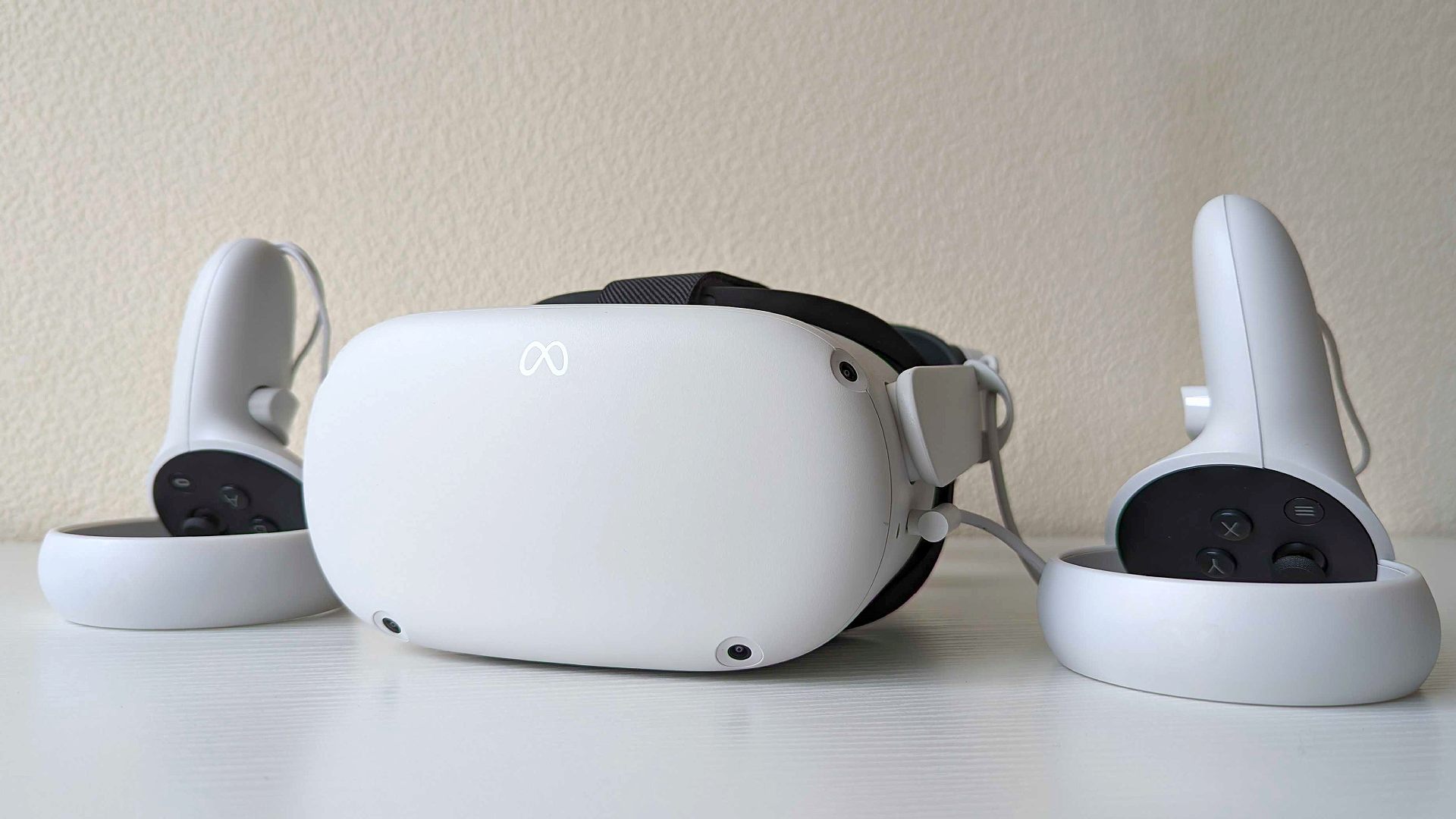 ชุดหูฟัง VR ที่ดีที่สุด: Meta Quest 2 พร้อมคอนโทรลเลอร์บนพื้นผิวสีขาว