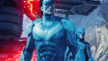 Gotham Knights patch PC performance: Nightwing and Batgirl are seen lit in pale blue light in an underground cave, with a structure behind them that pulses with ominous red energy
