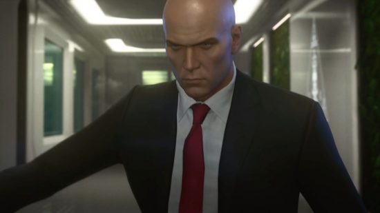 Hitman devs are making an "online fantasy RPG," yes, seriously: A bald man wearing a suit and red tie in a hallway
