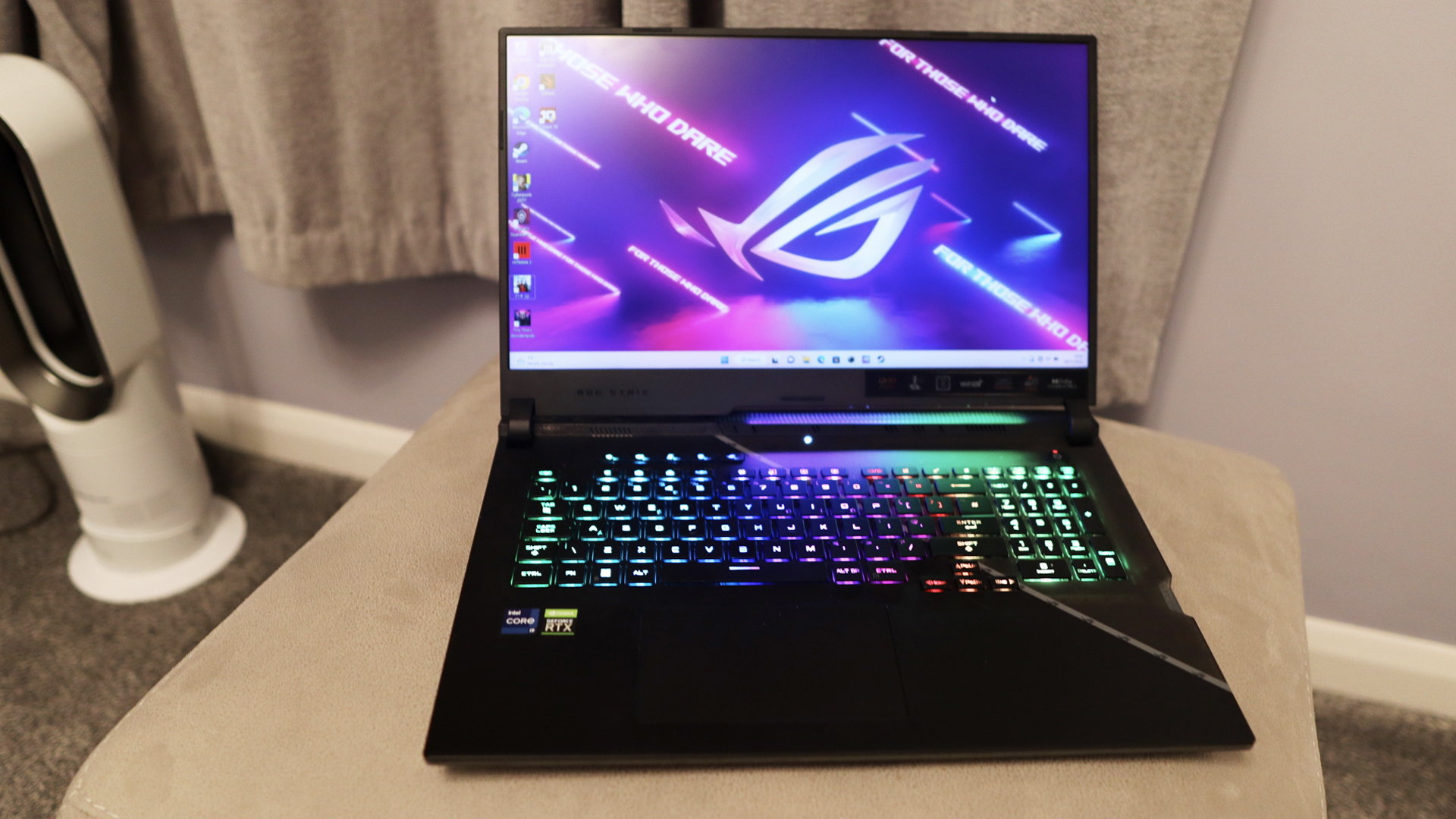 Asus ROG Strix Scar 17 review: Gaming laptop on beige stand, RGB keyboard glows