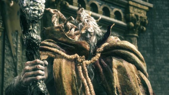 Elden Ring bosses: Margit the Fell Omen standing to attention at his post above Stormveil Castle, wrapped in a linen cloak and holding his gnarled staff.