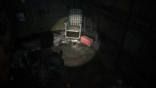The Last of US workbench tool locations: a man points his flashlight at a dark corner of a workshop.