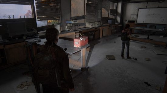 The Last of US workbench tool locations: a man points his flashlight at a red toolbox sitting on a table.