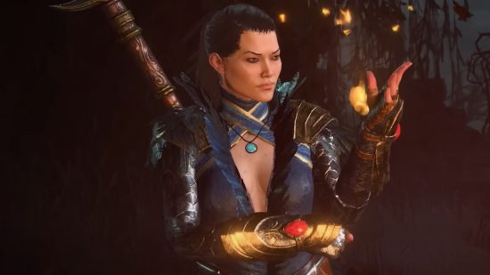 Hardcore Diablo 4 PvP is just that, so don't die: An Asian woman with black hair tied back on a ponytail conjures fire in her right hand wearing a plunging blue robe adorned with gold in a cavern