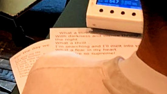 MGS 3 - close-up tweet dari Donna Burke yang menampilkan lirik tema MGS3 'Snake Eater' di selembar kertas yang ditinggalkan di atas meja