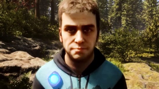 Sons of the Forest Patch 4 - Kelvin, en brunhårig man som bär en svart hoodie med en blå rand över axlarna