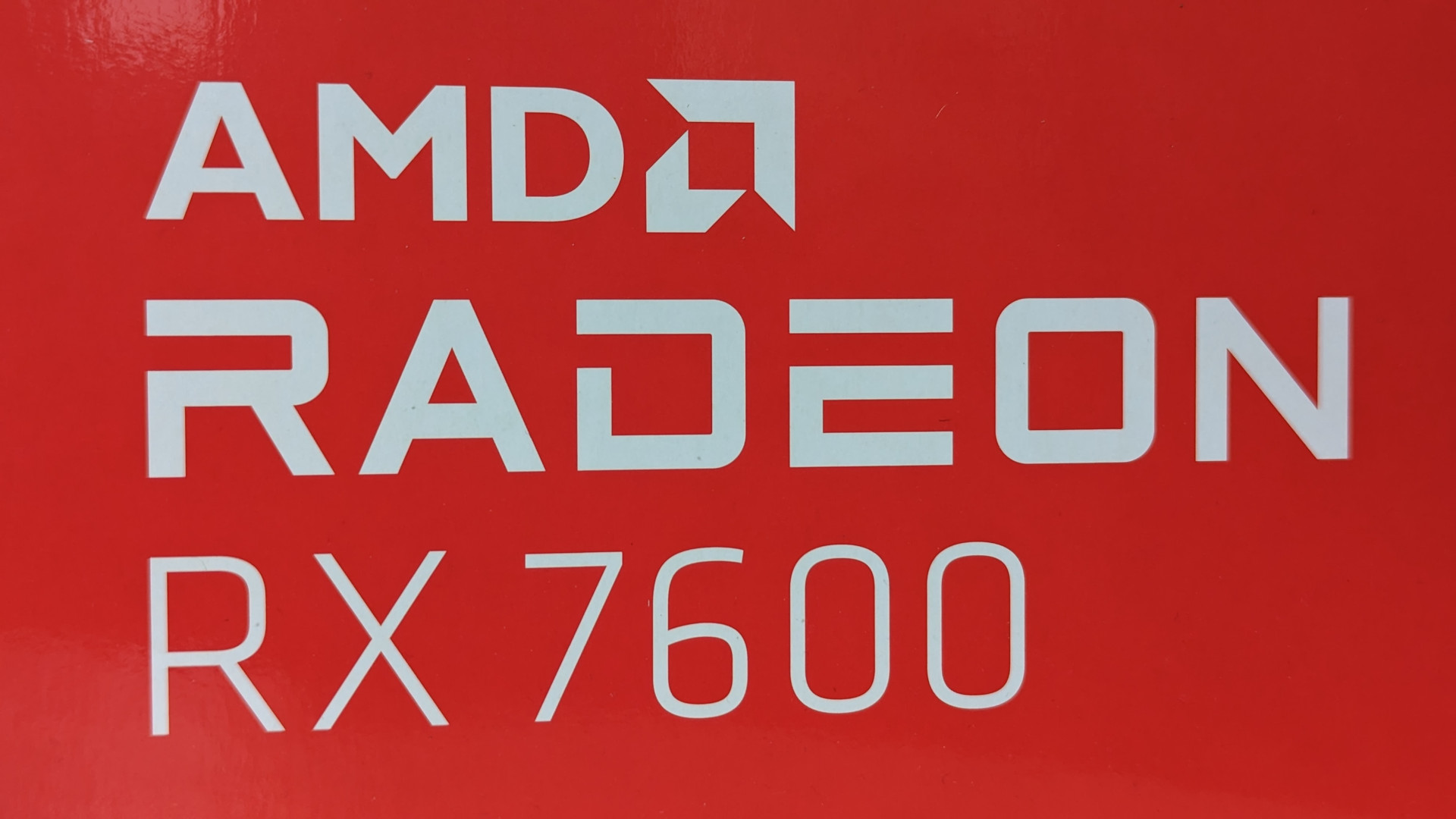 Revisión de AMD Radeon RX 7600: el texto blanco oficial 'AMD Radeon RX 7600' sobre un fondo rojo