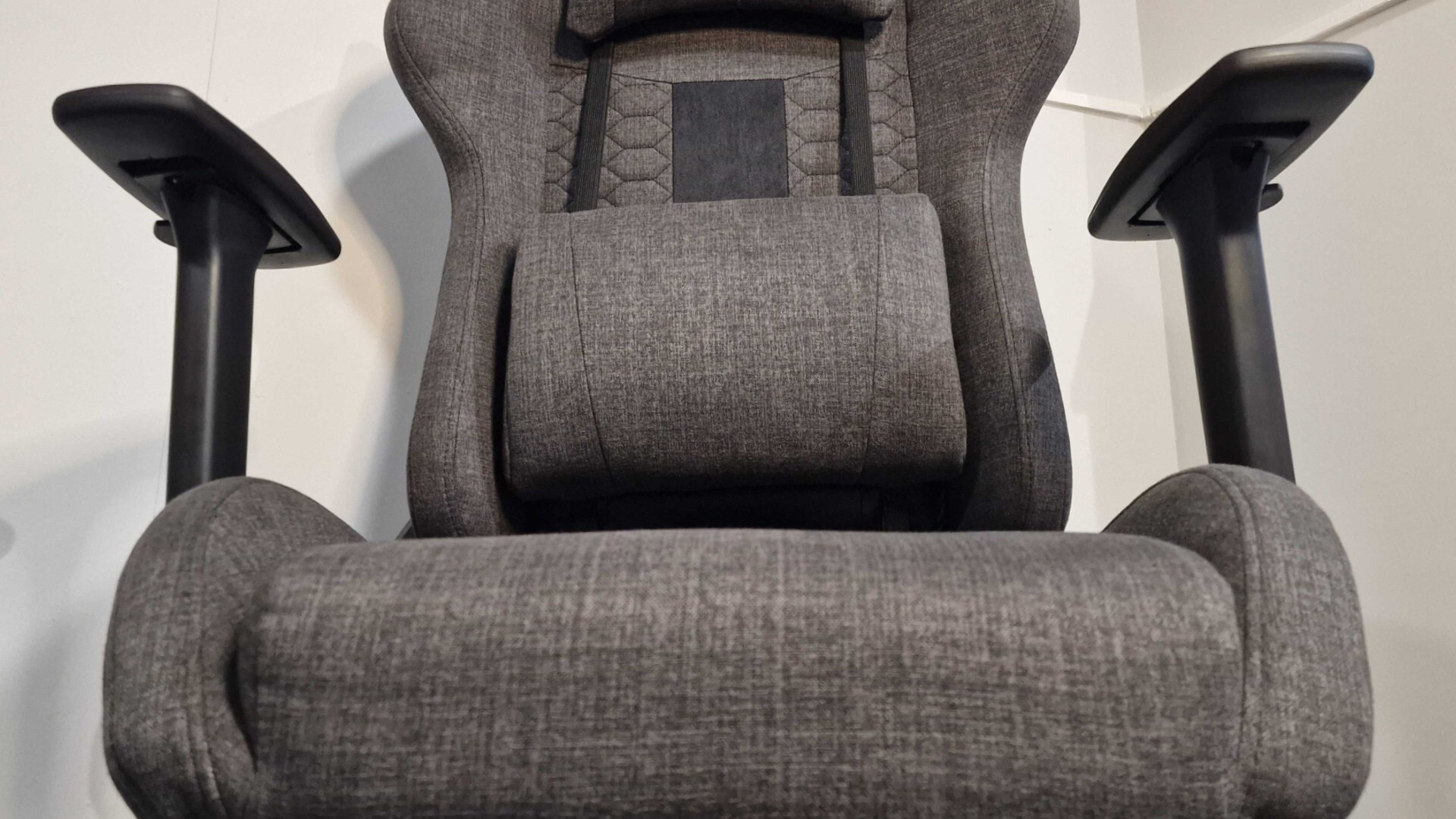 Corsair TC100 Relaxed review: The seatbase of a gaming chair, looking up at its armrests and lumbar cushion