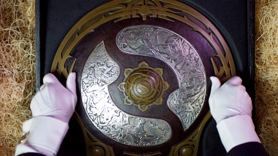 Dota 2 The International 2023 - white-gloved hands carefully place the Aegis of Champions into a straw-filled box for transport