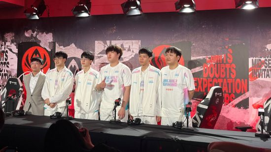Un grupo de jugadores chinos de League of Legends de BBG con uniformes blancos se paran frente a un fondo negro y rojo