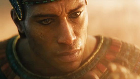 Total War Pharaoh is coming sooner rather than later: A tanned man wearing Egyptian clothing raises a scarab to his face
