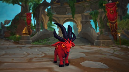 A small red ram with glowing orange eyes and curved black horns stands in forest ruins