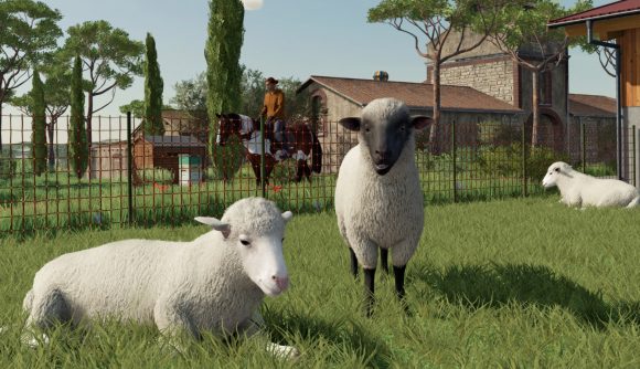 A screenshot of Farming Simulator 22 showing three sheep, with two laying down and one standing between them