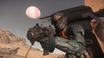 A soldier stands on a planet wearing space-like armor while wielding a gun