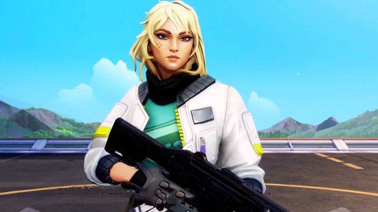 Deadlock is Valorant's first perfectly balanced agent: A blond woman wearing a white bomber jacket with a green jumper underneath stands holding a rifle looking into the camera on a sunny blue background