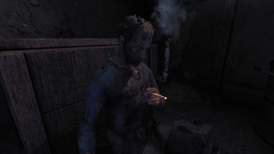 A WW1-era soldier sits with his head bowed smoking a cigarette in a dark trench