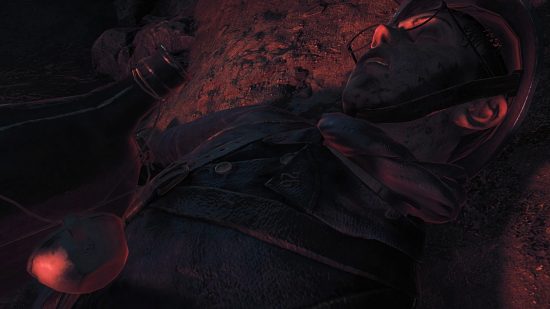 A WW1 soldier lying dead on the ground bathed in red light