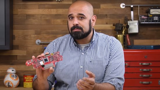 Photo of the host of the iFixit YouTube channel holding up the motherboard of an ASUS ROG Ally.