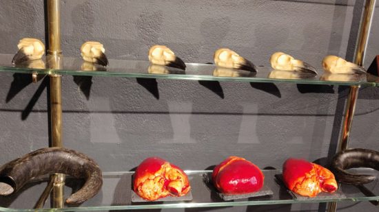 Diablo 4 chocolate shop - chocolate 'raven skulls' on a shelf above similarly chocolate 'horns' and 'hearts' below.
