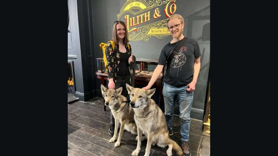 Diablo 4 chocolate shop - PCGamesN staff Lauren and Ken stand with two real-life 'wolves' in the promotional store.