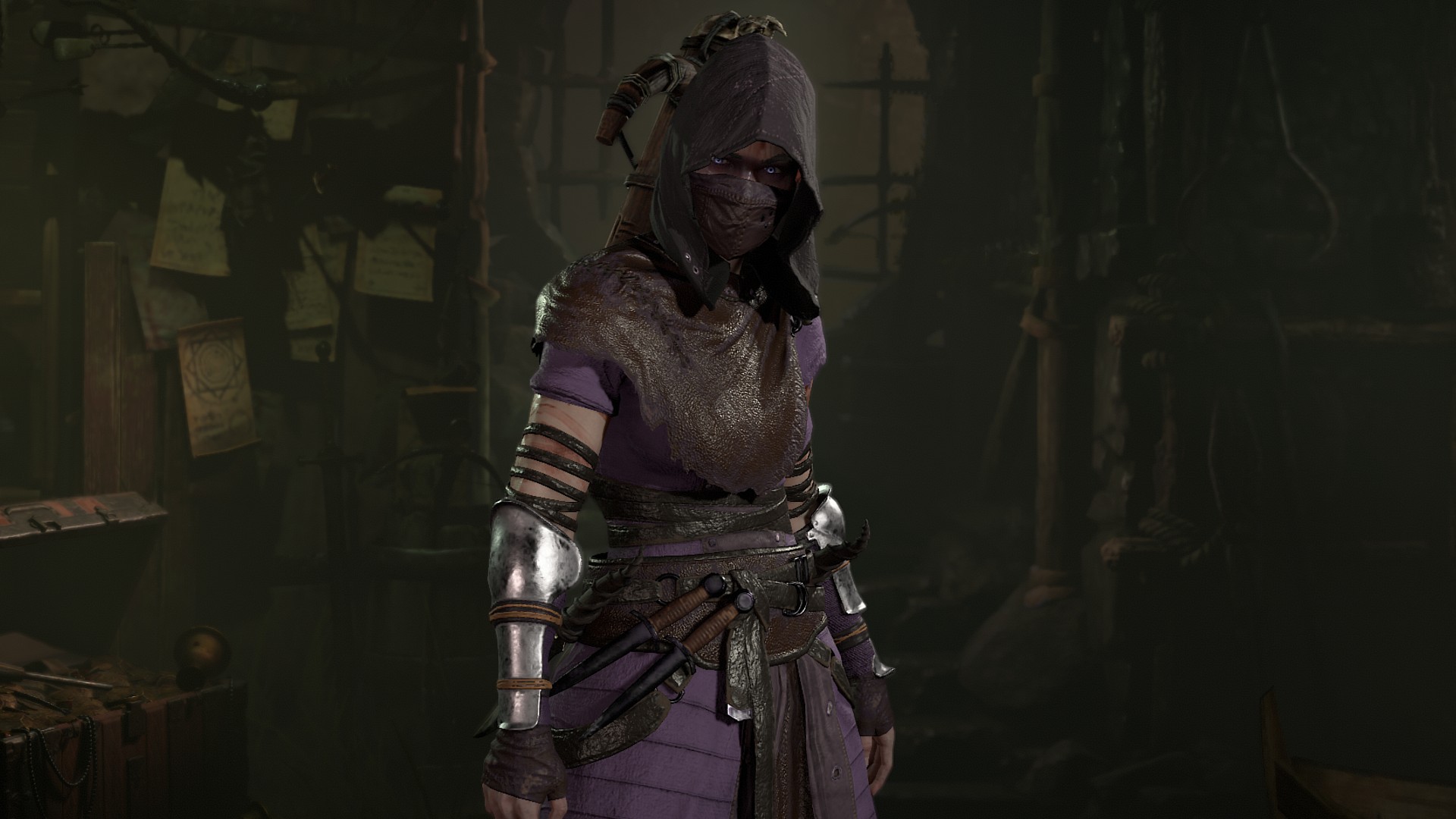Diablo 4 class: A woman wearing a hood that covers her face, as well as a black mask with purple cloth armour and a belt around her waist in a shadowy dungeon room