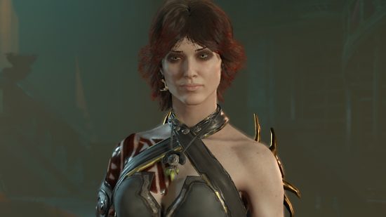 A woman with black hair with red tips wearing a black halter neck leather armor with a tattoo painted in blood looks past the camera