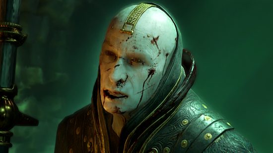 Diablo 4 patch notes 1.02 hotfix 11 - Elias, a pale man with a shaved head wearing black and gold robes grimaces, flecks of blood across his face.