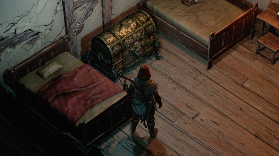A male rogue looking at a large golden chest in a dimly lit room