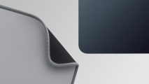 hard vs soft mouse pad: Two mouse pads are in shot - one is upside down with the corner furled and the other is flat on a desk
