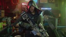 A tanned, hooded man with a goatee standing holding a sniper rifle in a basement location