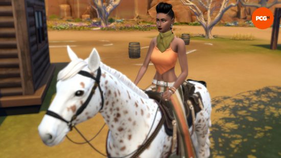 A female Sims rides atop a white and brown spotted horse in the desert